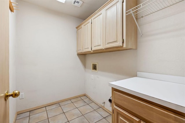 laundry room featuring hookup for a washing machine, light tile patterned floors, visible vents, baseboards, and cabinet space