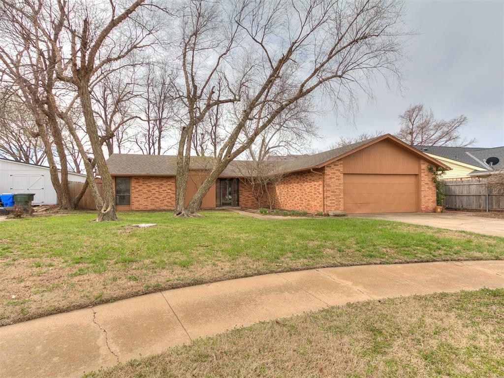 view of front facade with fence, concrete driveway, a front yard, a garage, and brick siding