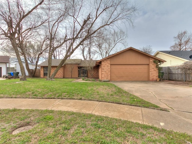 view of front of home featuring fence, a front lawn, concrete driveway, a garage, and brick siding