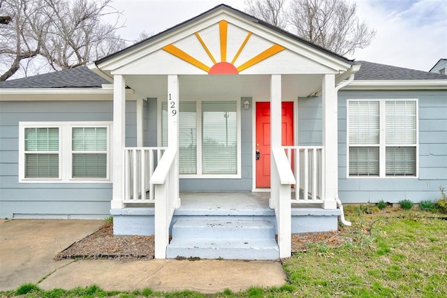 exterior space featuring a porch and roof with shingles