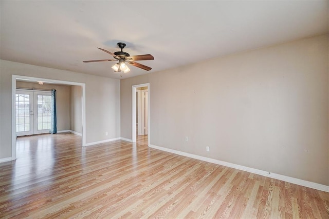 spare room with light wood-style flooring, french doors, and baseboards