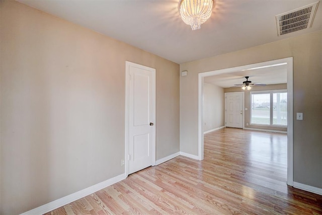 empty room featuring visible vents, light wood-style floors, and baseboards