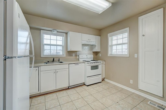 kitchen featuring white appliances, visible vents, a sink, light countertops, and under cabinet range hood