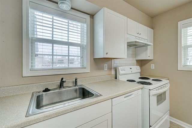 kitchen with under cabinet range hood, light countertops, white appliances, white cabinetry, and a sink