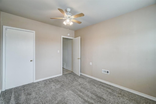 unfurnished bedroom featuring visible vents, baseboards, carpet, and a ceiling fan