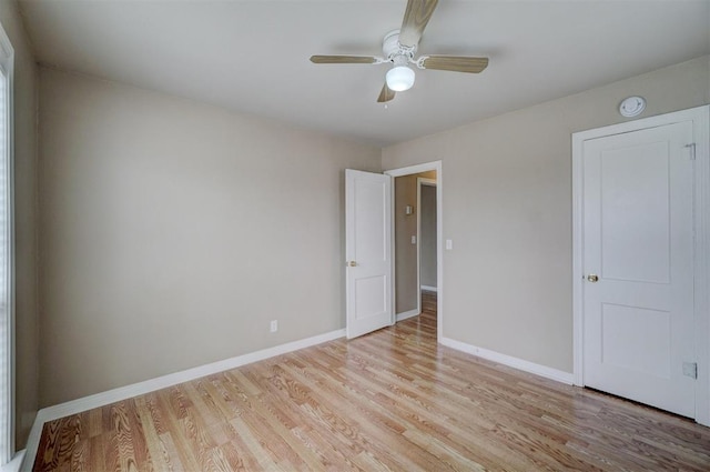 spare room featuring baseboards, a ceiling fan, and light wood finished floors