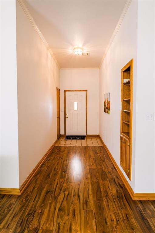 interior space with crown molding, wood finished floors, and baseboards