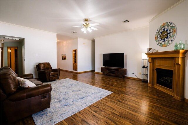 living room with visible vents, baseboards, dark wood finished floors, a fireplace, and crown molding