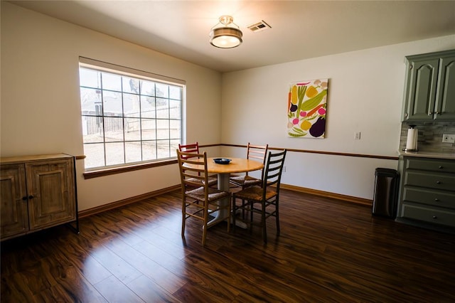 dining area featuring visible vents, baseboards, and dark wood finished floors