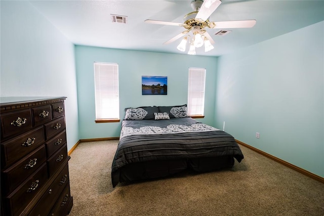 bedroom with visible vents, baseboards, light colored carpet, and a ceiling fan