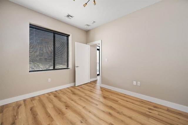 spare room with wood finished floors and baseboards
