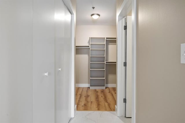 walk in closet featuring marble finish floor