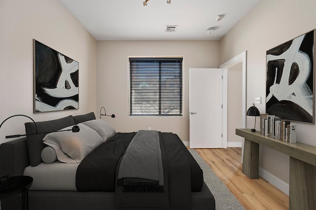 bedroom featuring light wood-style flooring, baseboards, and visible vents
