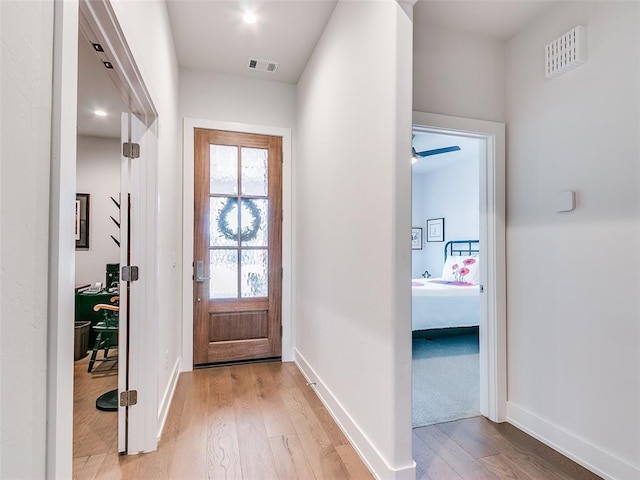 foyer featuring light wood-style flooring, baseboards, and visible vents