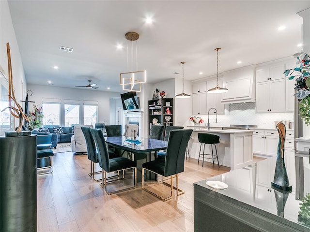 dining space with visible vents, a fireplace, recessed lighting, ceiling fan, and light wood-style floors