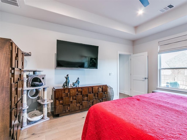 bedroom featuring visible vents, recessed lighting, a raised ceiling, and wood finished floors