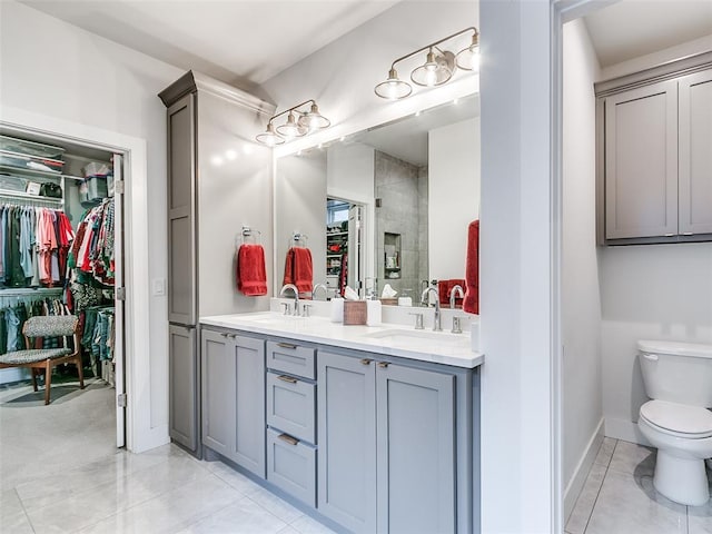 bathroom featuring a sink, a walk in closet, and double vanity