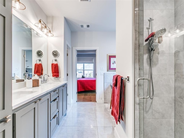 ensuite bathroom with visible vents, a sink, ensuite bath, double vanity, and tiled shower