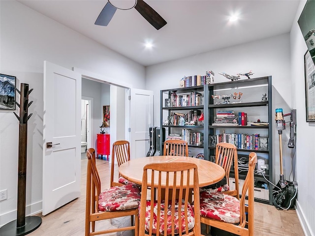 dining space with light wood finished floors, baseboards, and ceiling fan