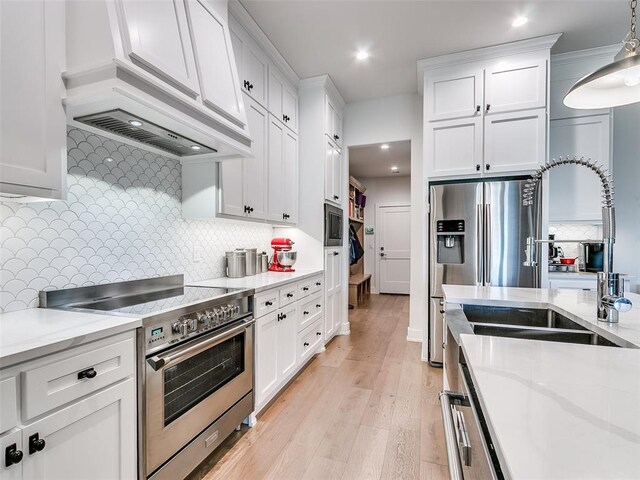 209 Pont Neuf Ct, Edmond, OK 73034 - kitchen with appliances with stainless steel finishes, white cabinetry, decorative backsplash, recessed lighting, and light wood-style floors