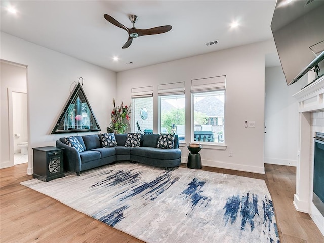 209 Pont Neuf Ct, Edmond, OK 73034 - living area with ceiling fan, a tile fireplace, wood finished floors, baseboards, and recessed lighting