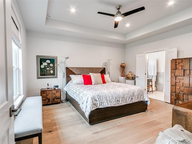 209 Pont Neuf Ct, Edmond, OK 73034 - bedroom with a raised ceiling, light wood-style floors, ensuite bath, recessed lighting, and a ceiling fan