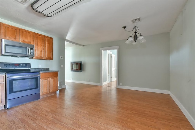 kitchen featuring visible vents, brown cabinets, appliances with stainless steel finishes, and light wood-type flooring