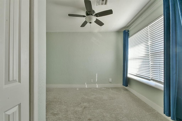 spare room featuring visible vents, ceiling fan, baseboards, and carpet