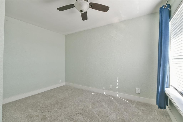 empty room with carpet flooring, a textured wall, and baseboards