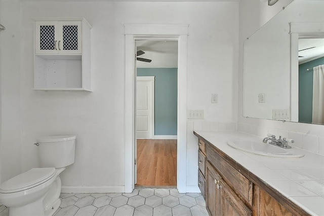 bathroom featuring vanity, toilet, and baseboards