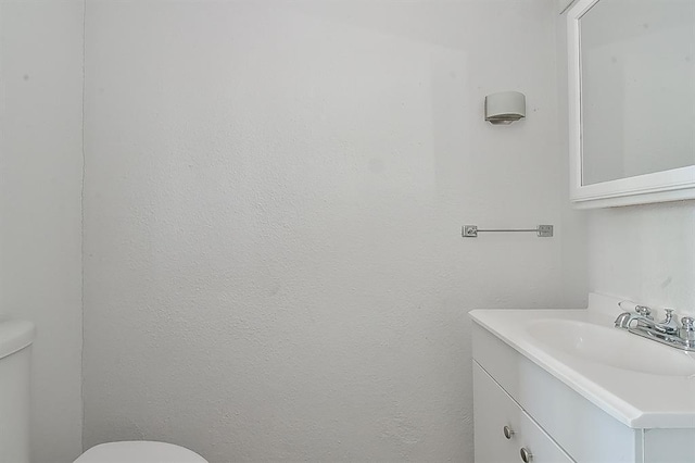 half bathroom with toilet and vanity