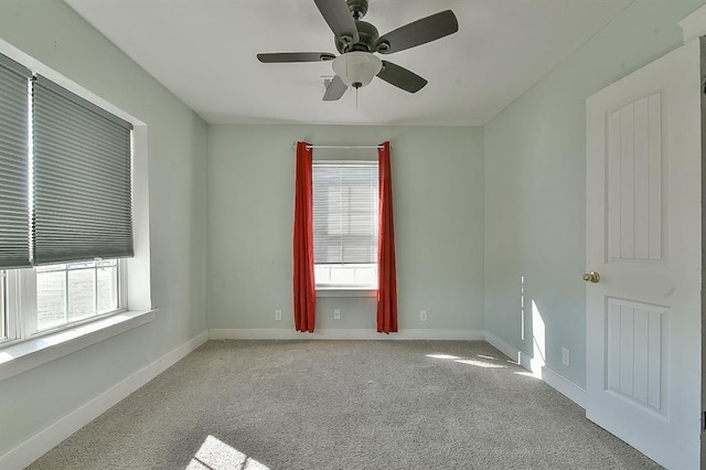 empty room featuring baseboards, ceiling fan, and carpet flooring