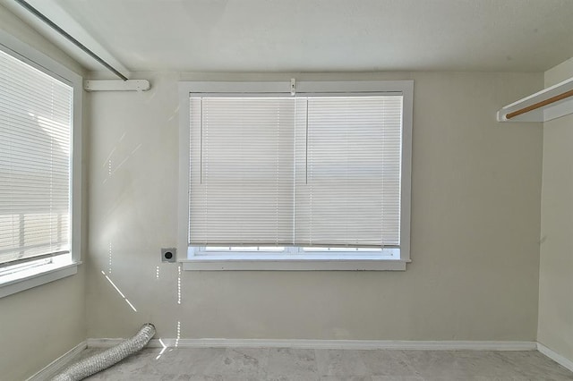 interior space featuring baseboards, hookup for an electric dryer, and laundry area