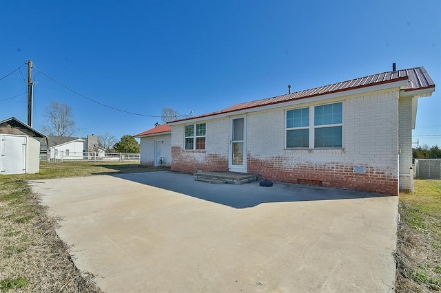 ranch-style house with crawl space, metal roof, brick siding, and fence