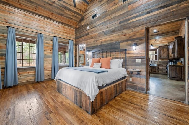 bedroom featuring wooden walls, wooden ceiling, high vaulted ceiling, and wood-type flooring