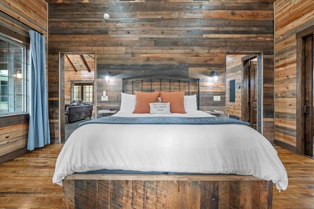 bedroom with a high ceiling, wood finished floors, and wood walls