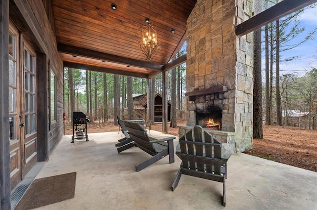 view of patio / terrace with an outdoor stone fireplace and a grill