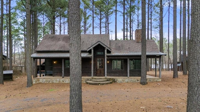 rustic home with roof with shingles and a chimney