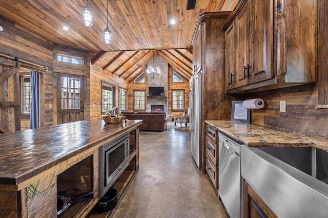 kitchen with wooden walls, a fireplace, stainless steel appliances, wood ceiling, and concrete flooring