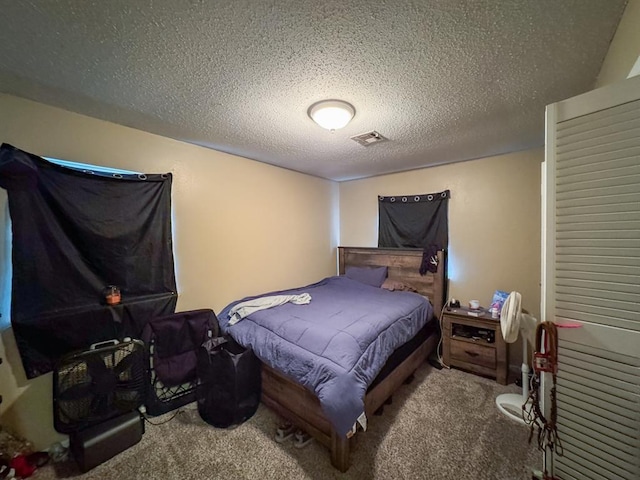 bedroom with visible vents, a textured ceiling, and carpet floors