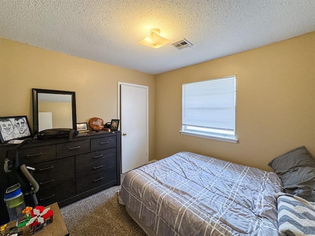 carpeted bedroom featuring visible vents and a textured ceiling