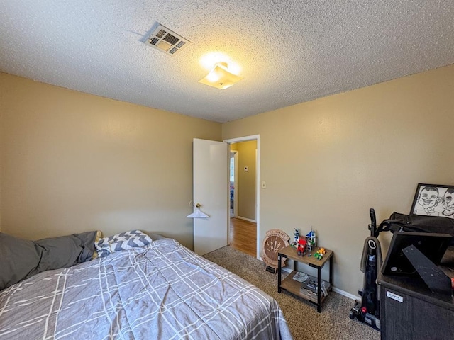 carpeted bedroom with visible vents and a textured ceiling