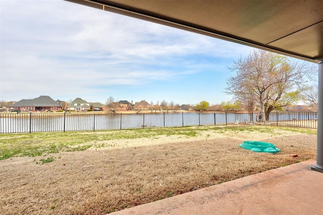 view of yard featuring a water view and fence