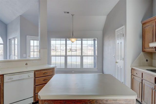 kitchen featuring a wealth of natural light, visible vents, white dishwasher, and vaulted ceiling