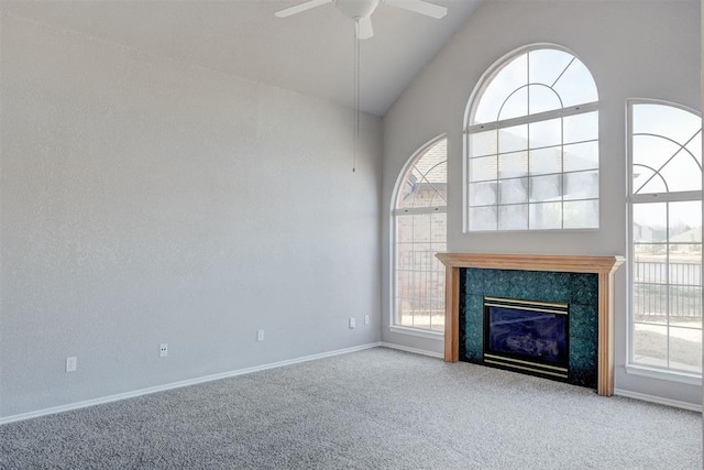 unfurnished living room with high vaulted ceiling, carpet flooring, baseboards, and ceiling fan