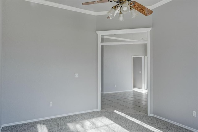 tiled spare room featuring carpet flooring, baseboards, ceiling fan, and ornamental molding