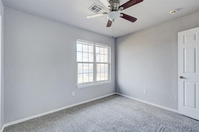 unfurnished room featuring visible vents, carpet floors, baseboards, and a ceiling fan