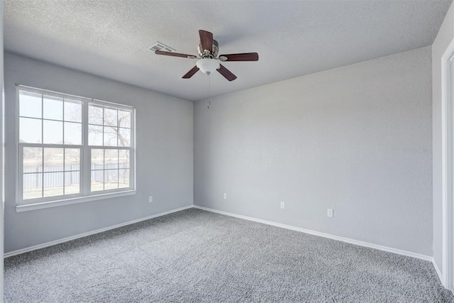 spare room featuring a textured ceiling, baseboards, a ceiling fan, and carpet floors