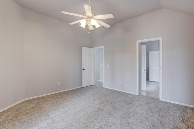 unfurnished room featuring baseboards, lofted ceiling, light colored carpet, and ceiling fan