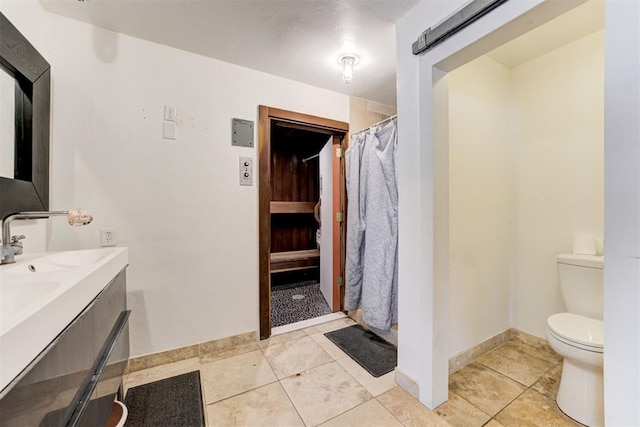 bathroom featuring tile patterned floors, a shower with curtain, baseboards, and toilet